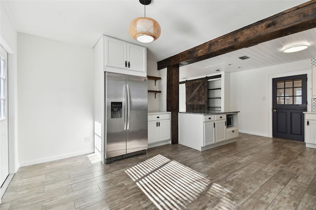 kitchen featuring white cabinets, stainless steel fridge with ice dispenser, a barn door, and light hardwood / wood-style flooring