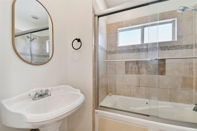 bathroom featuring sink and enclosed tub / shower combo