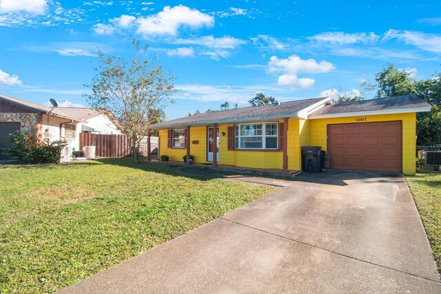 single story home with cooling unit, a garage, and a front yard