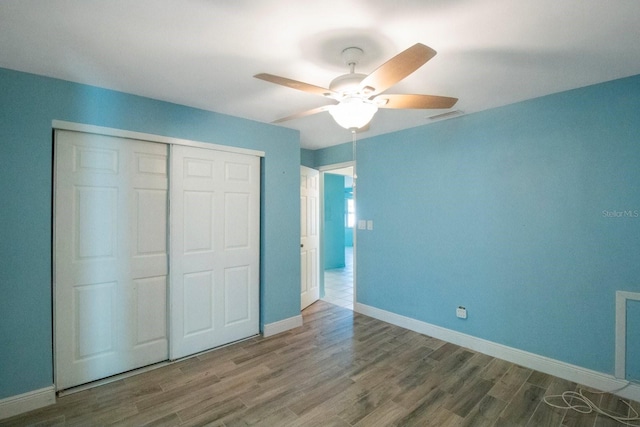 unfurnished bedroom featuring wood-type flooring, a closet, and ceiling fan