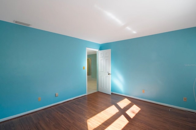 unfurnished room featuring dark wood-type flooring