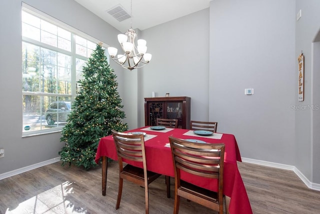 dining area featuring hardwood / wood-style floors and an inviting chandelier