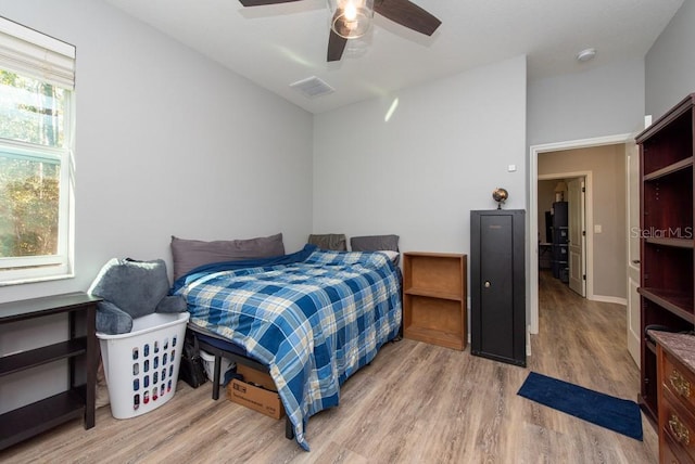 bedroom with multiple windows, ceiling fan, and light wood-type flooring