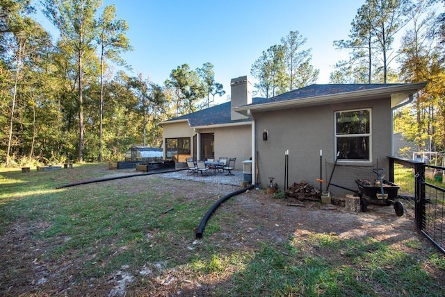 rear view of property with a yard and a patio