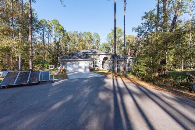 ranch-style home with solar panels and a garage