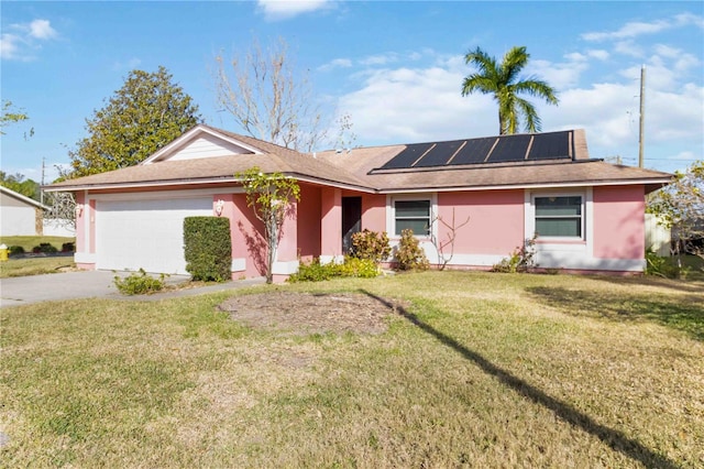 ranch-style house featuring solar panels, a garage, and a front yard