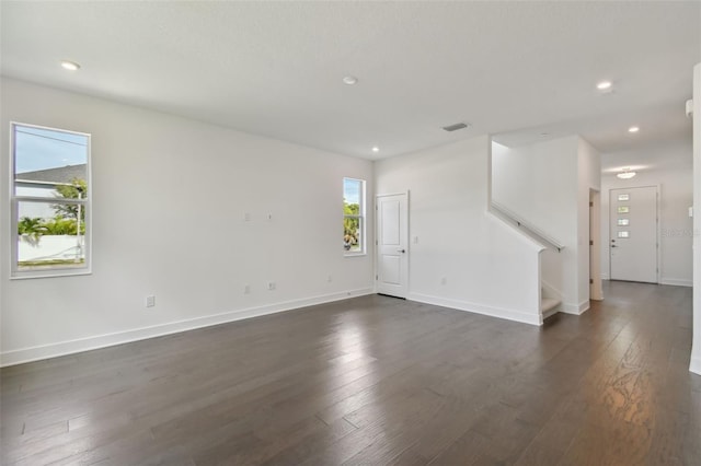 spare room with plenty of natural light and dark wood-type flooring