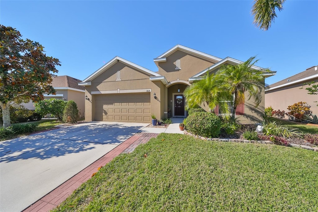 view of front of home with a front yard and a garage