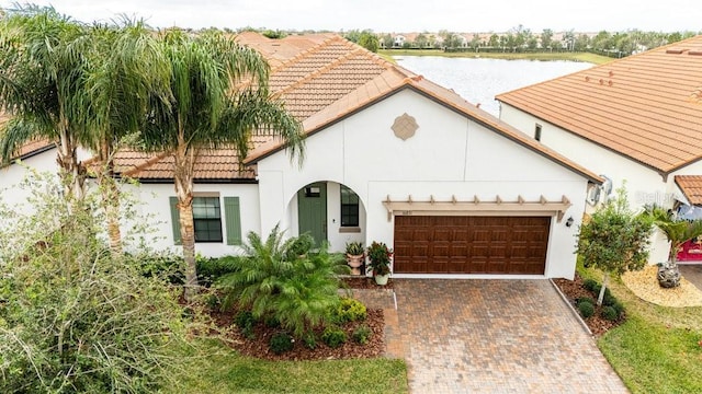 mediterranean / spanish home with a garage and a water view