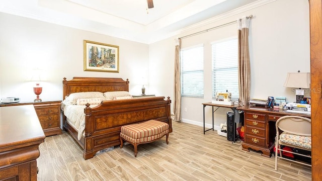 bedroom with light hardwood / wood-style floors, a raised ceiling, and ceiling fan