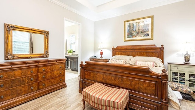 bedroom featuring connected bathroom, light hardwood / wood-style flooring, and ornamental molding