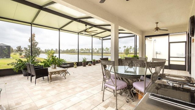 sunroom / solarium featuring ceiling fan, a water view, and vaulted ceiling