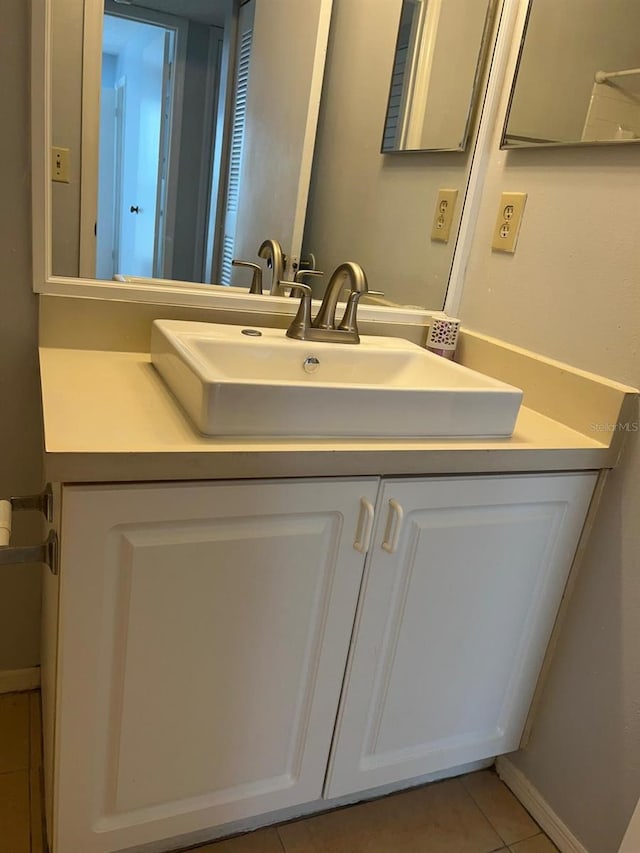 bathroom with tile patterned flooring, vanity, and baseboards