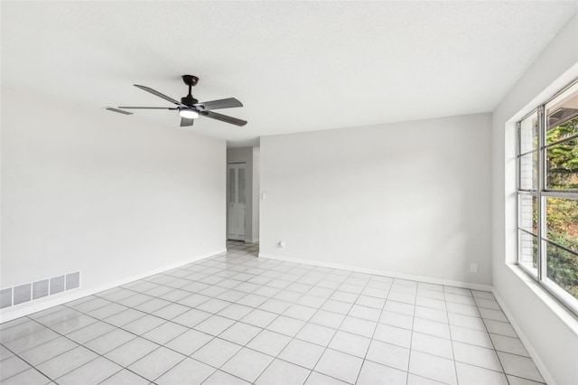 tiled spare room featuring a textured ceiling and ceiling fan