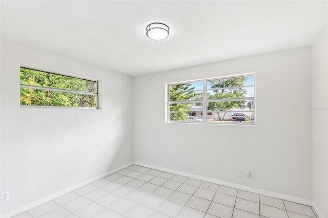 spare room with a healthy amount of sunlight and light tile patterned flooring