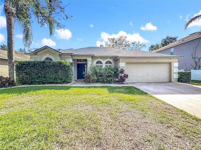 ranch-style house with a garage and a front lawn