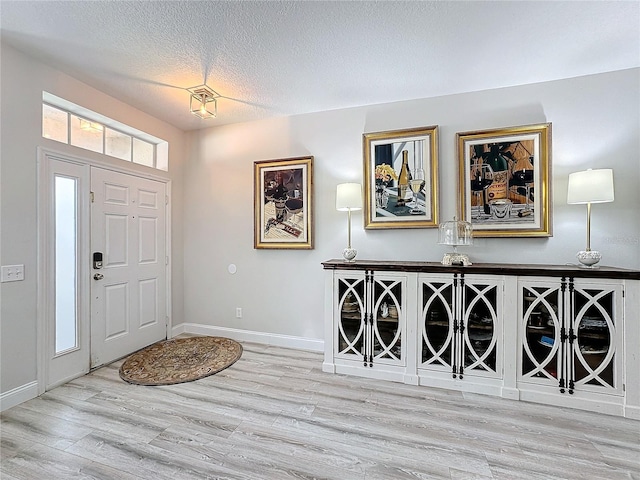 entrance foyer featuring light hardwood / wood-style floors and a textured ceiling