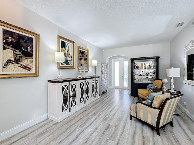 interior space featuring a textured ceiling and light hardwood / wood-style flooring