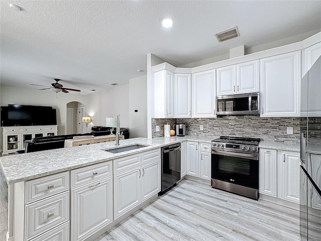 kitchen featuring kitchen peninsula, stainless steel appliances, sink, light hardwood / wood-style flooring, and white cabinetry