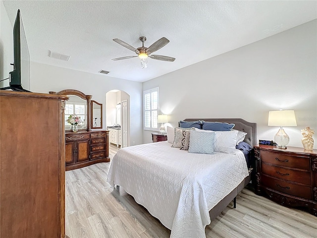 bedroom featuring a textured ceiling, light wood-type flooring, and ceiling fan