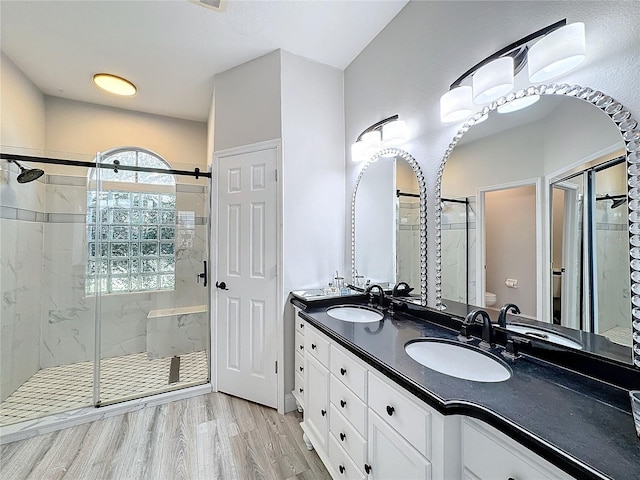 bathroom featuring toilet, vanity, wood-type flooring, and walk in shower