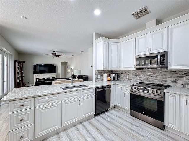 kitchen with white cabinets, sink, light hardwood / wood-style floors, kitchen peninsula, and stainless steel appliances