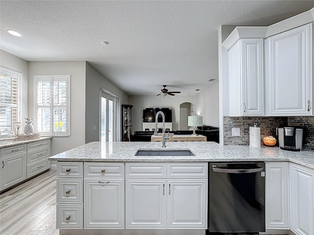 kitchen with white cabinetry, dishwasher, a textured ceiling, and light wood-type flooring