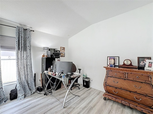 office area with light hardwood / wood-style floors and vaulted ceiling