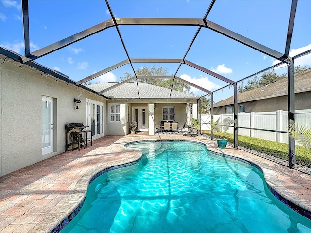 view of swimming pool with french doors, glass enclosure, and a patio area