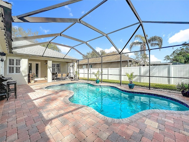 view of swimming pool with a lanai, a patio area, and french doors