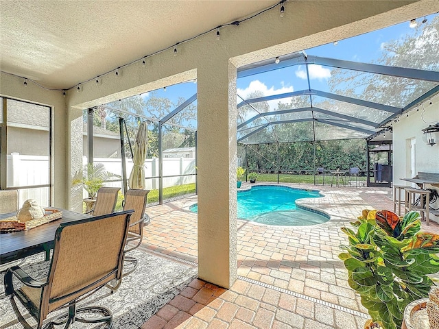 view of swimming pool featuring glass enclosure and a patio