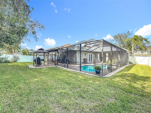 back of property with a gazebo, glass enclosure, a yard, and a fenced in pool