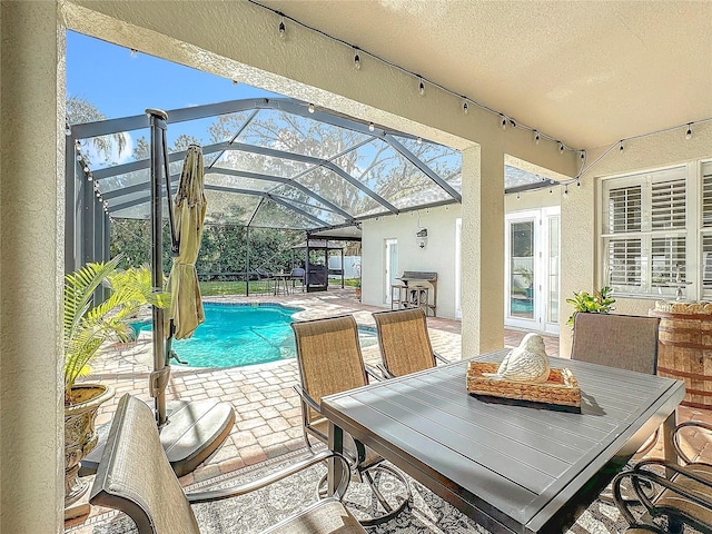 view of pool with a lanai, a patio area, grilling area, and french doors