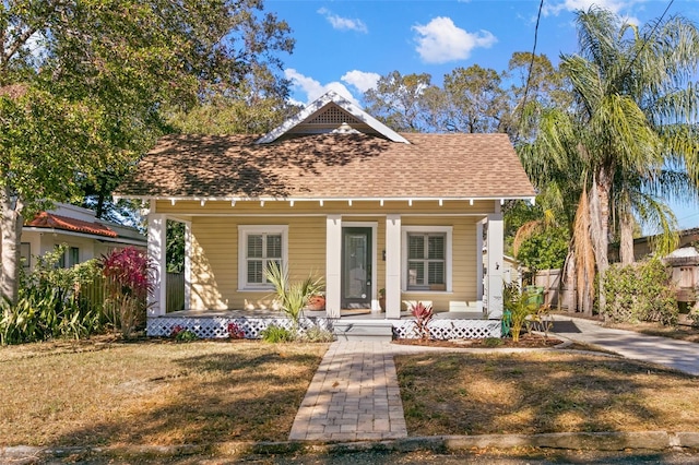 bungalow-style house featuring a front lawn and covered porch