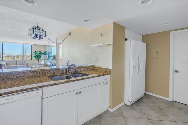 kitchen with white appliances, dark stone counters, sink, light tile patterned flooring, and white cabinetry