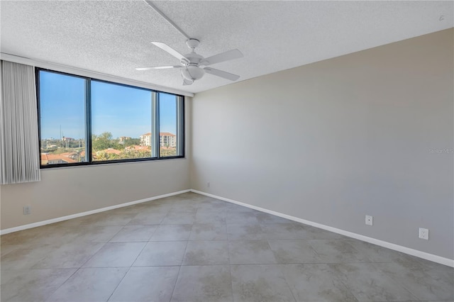 tiled empty room featuring a textured ceiling and ceiling fan