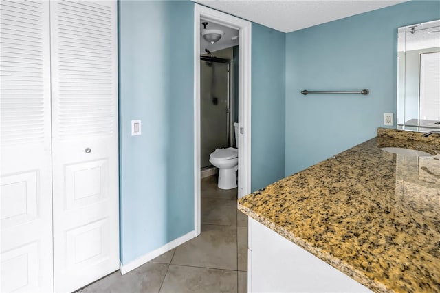 bathroom featuring tile patterned floors, vanity, toilet, and an enclosed shower