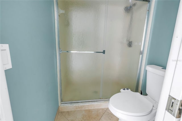 bathroom with tile patterned floors, a shower with door, and toilet