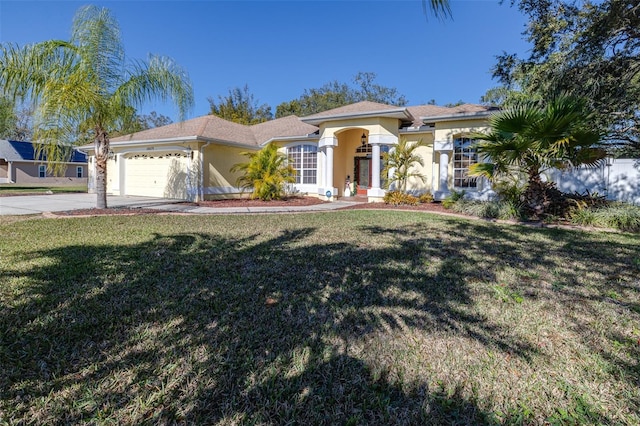 mediterranean / spanish-style home with a front yard and a garage