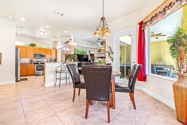 dining room featuring light tile patterned floors and ceiling fan with notable chandelier