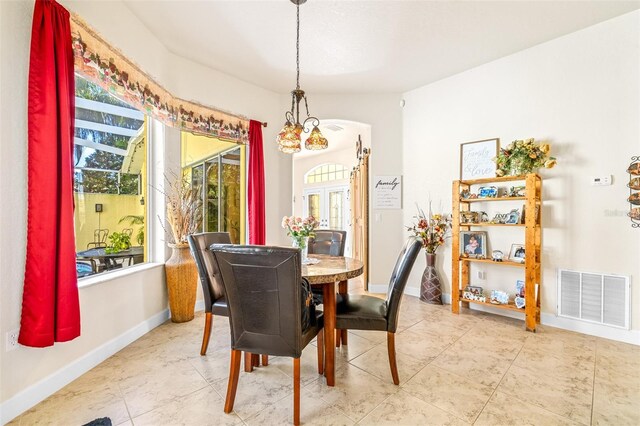 dining space featuring tile patterned floors and a notable chandelier