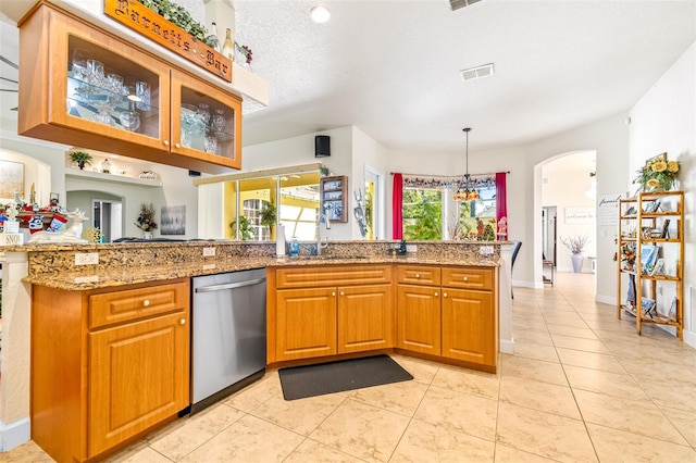 kitchen with sink, light stone counters, stainless steel dishwasher, a notable chandelier, and kitchen peninsula