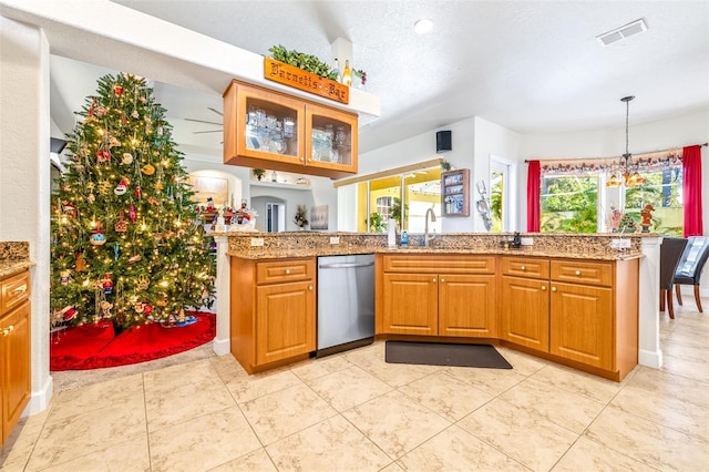 kitchen with kitchen peninsula, sink, stainless steel dishwasher, and a textured ceiling