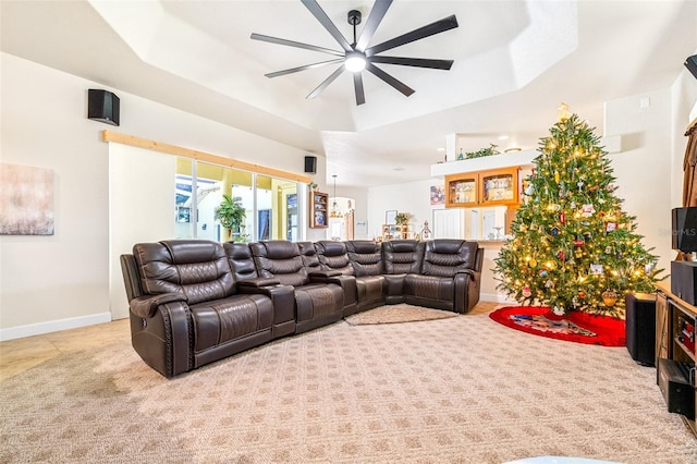 home theater featuring light colored carpet, a raised ceiling, and ceiling fan