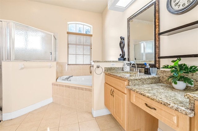 bathroom featuring tile patterned flooring, vanity, a skylight, and independent shower and bath