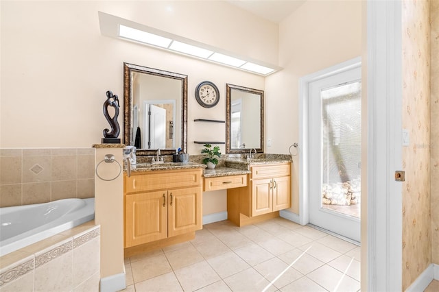 bathroom with tiled bath, tile patterned flooring, vanity, and a skylight