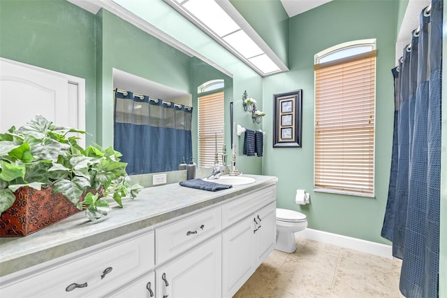 bathroom featuring tile patterned flooring, vanity, toilet, and plenty of natural light