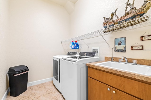 laundry area with cabinets, light tile patterned flooring, washer and clothes dryer, and sink