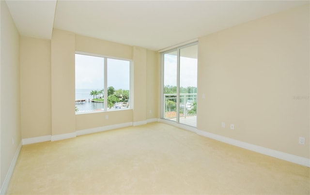 carpeted spare room with a water view