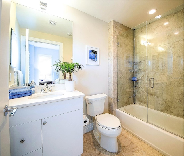 full bathroom featuring toilet, vanity, and shower / bath combination with glass door